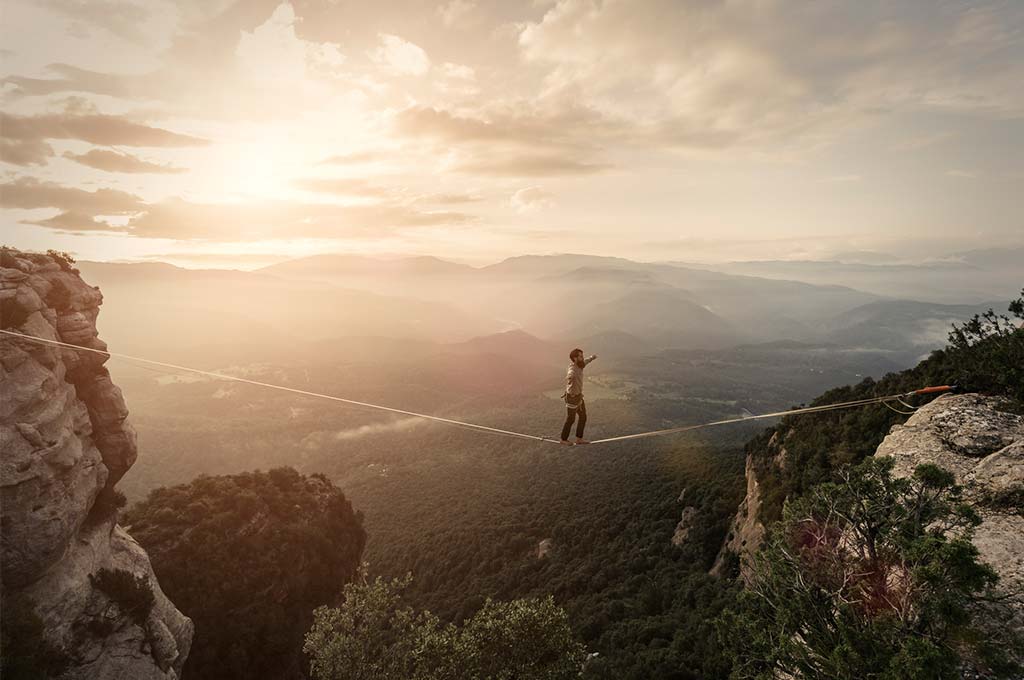 Un hombre highlining en las montañas.