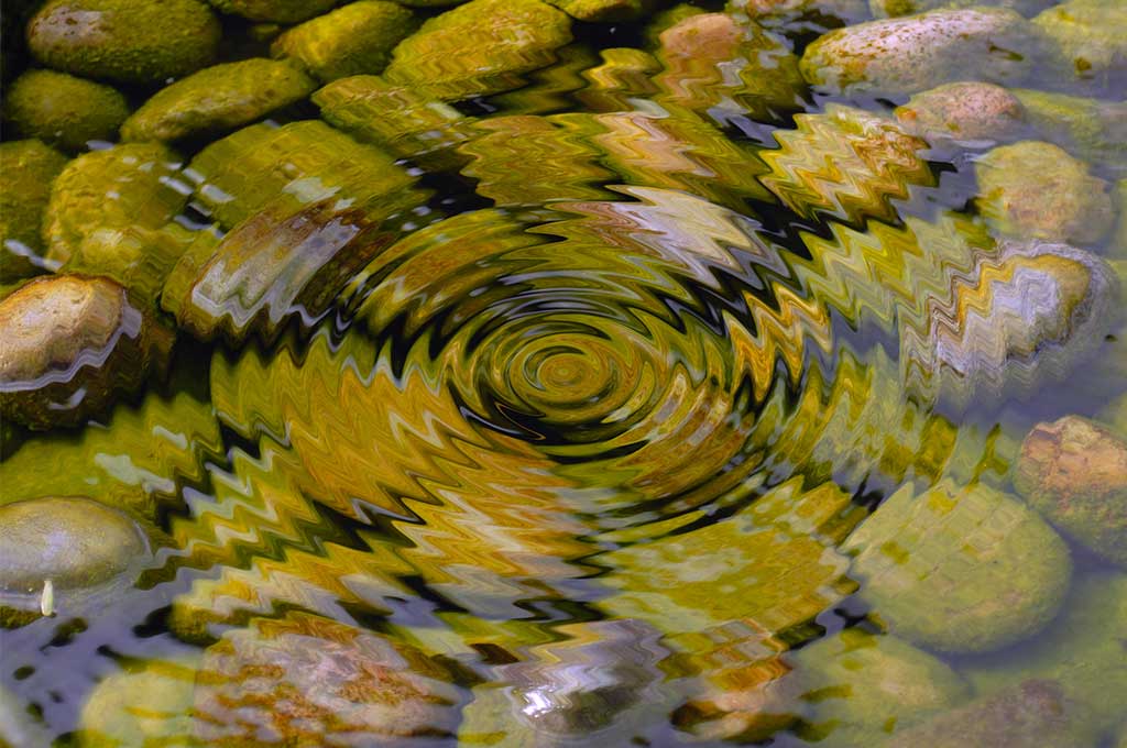 El rizado del agua con piedras en el fondo.