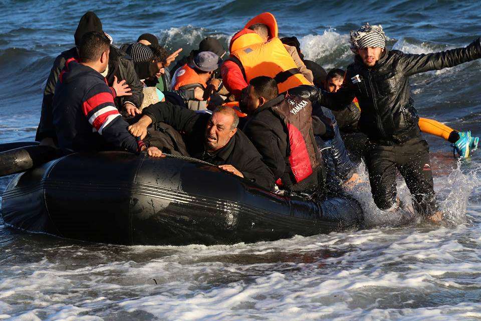 Una lancha llega a la playa con migrantes.