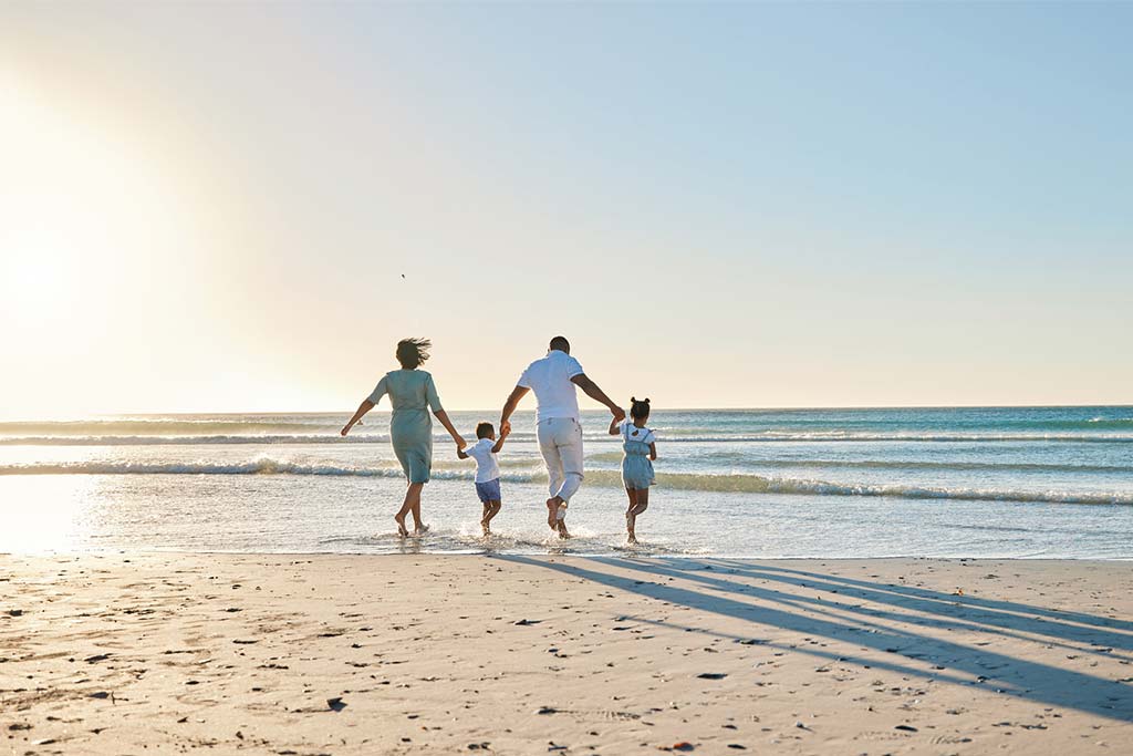 Familia da una paseo por la playa.