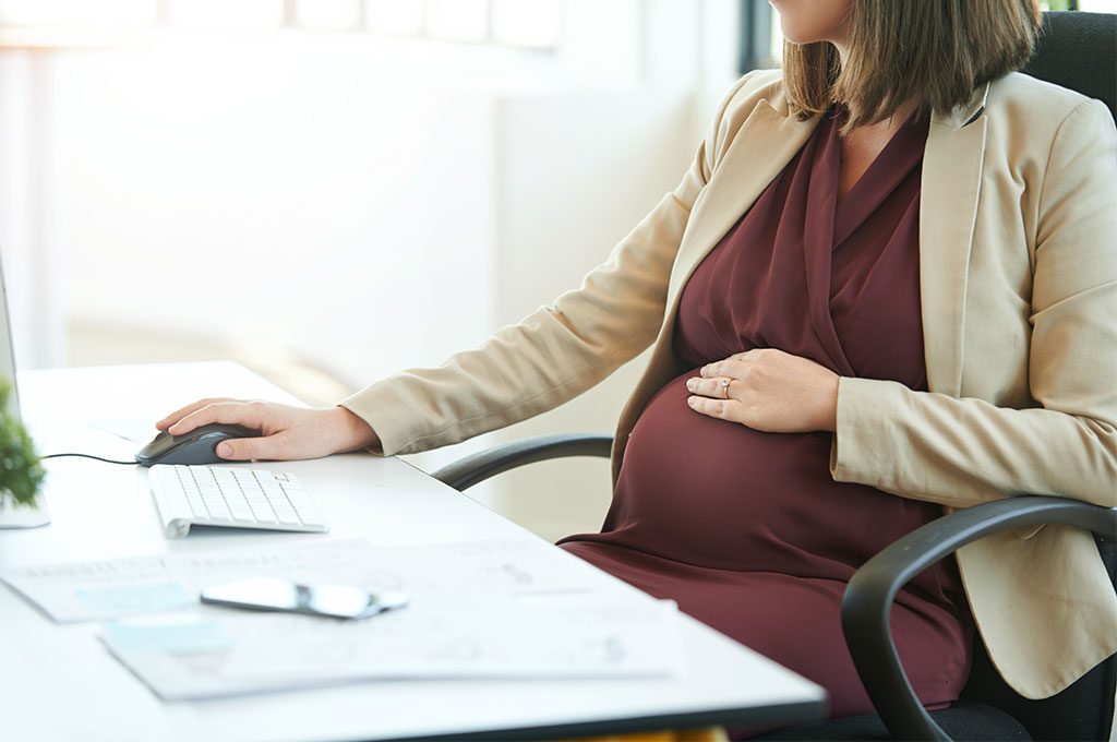 Mujer directiva embarazada en su mesa de trabajo