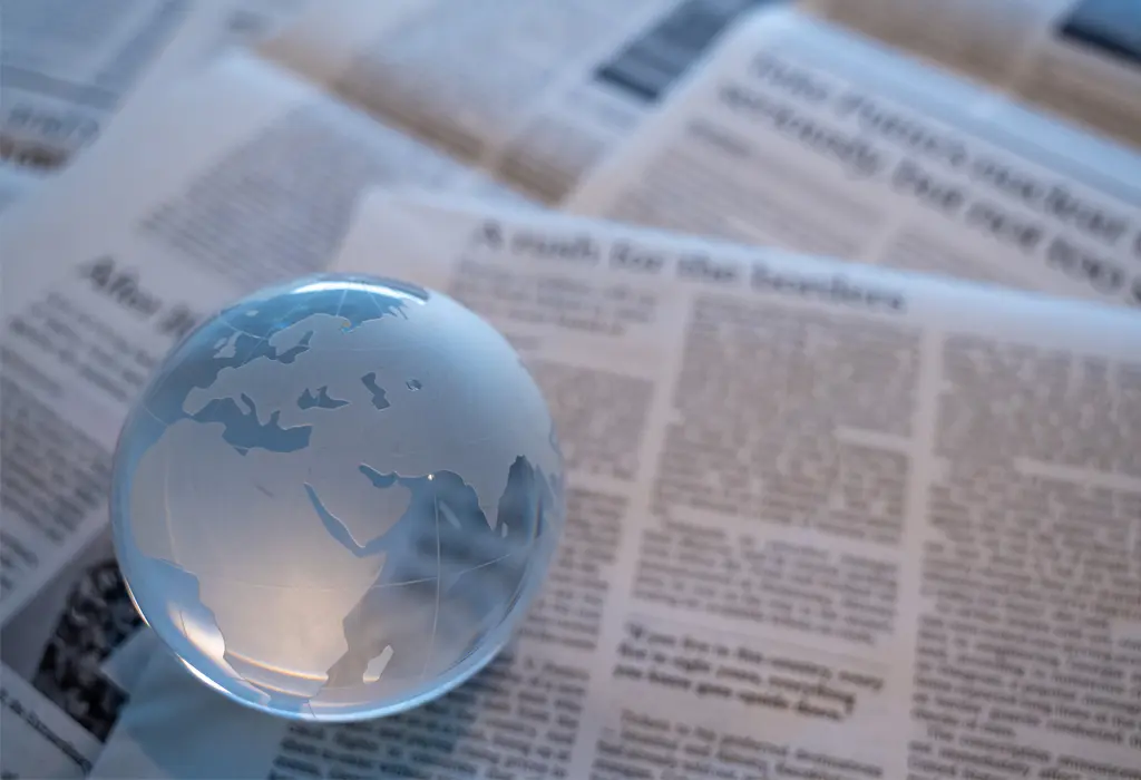 Bola del mundo de cristal sobre periódicos