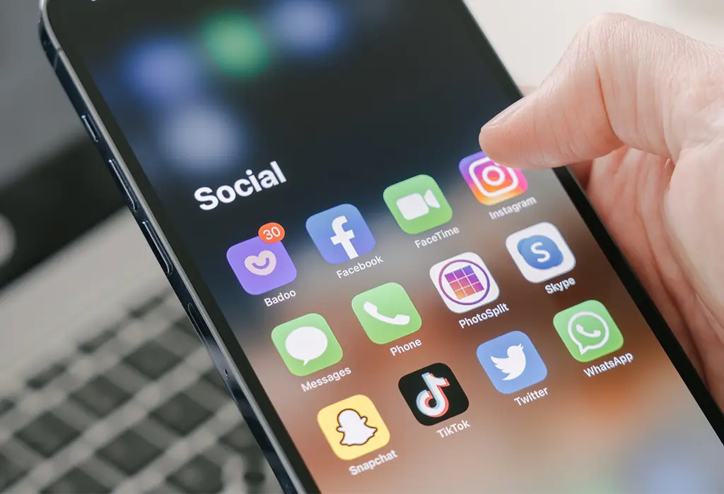 Usuario mirando el menú de aplicaciones de redes sociales en su teléfono móvil.