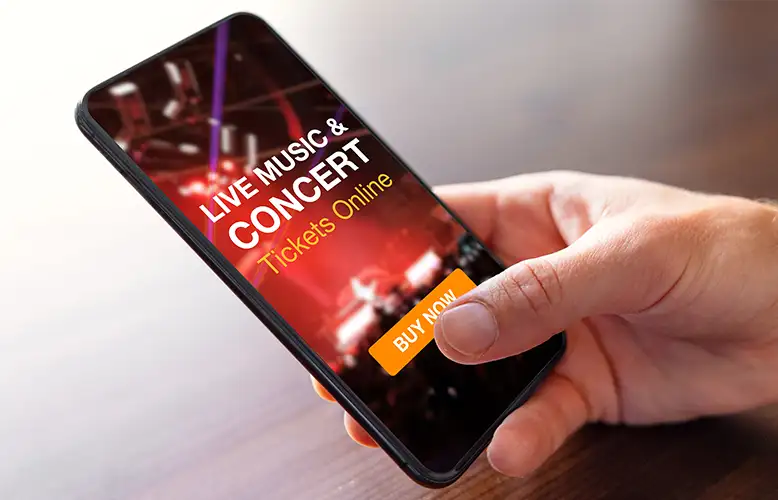 Usuario comprando entradas para un concierto desde un teléfono móvil.