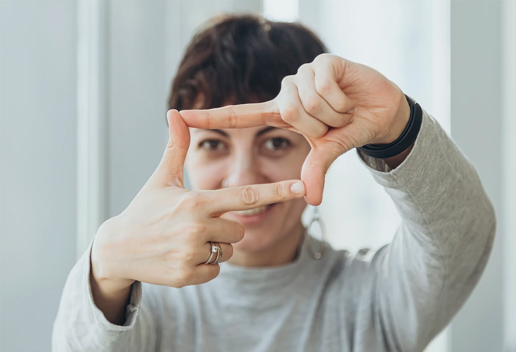 Una mujer crea la forma de un marco con los dedos