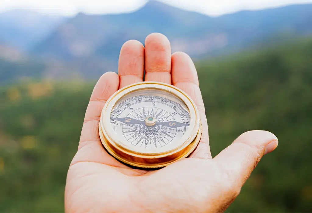 Hand holding a compass