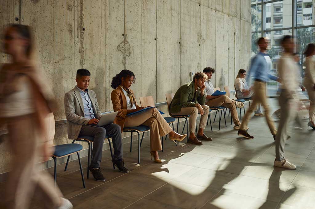 Group of candidates waiting for an interview in the company's hallway.
