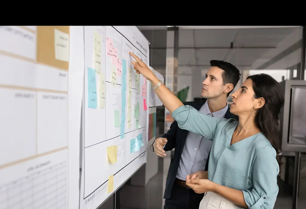 Two colleagues using sticky notes to plan a project together.