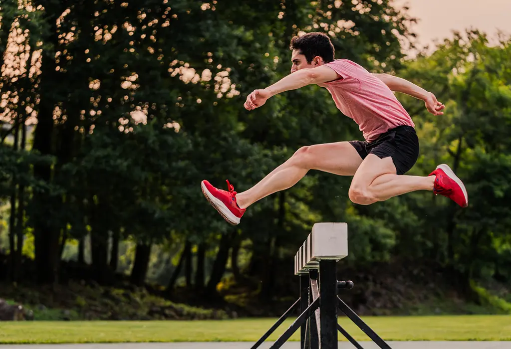 Runner jumping over a hurdle.