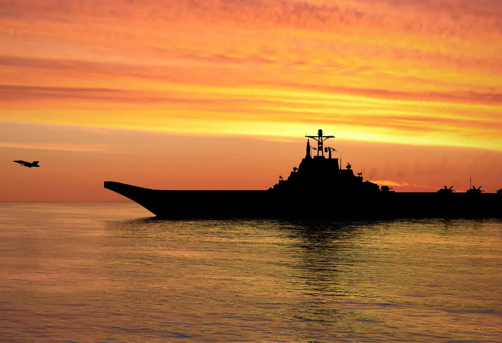 A cargo ship and a plane photographed against the light